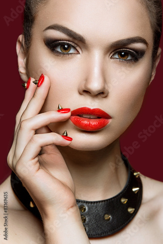 woman with evening make-up and red nails  thorns.