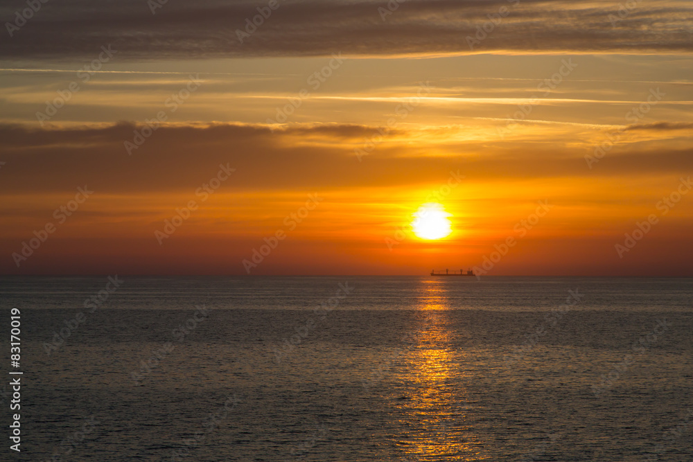 Sunset at sea with boat on the horizon