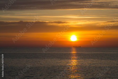 Sunset at sea with boat on the horizon