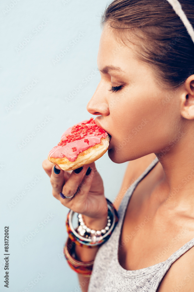 Attractive brunette sexy woman eating tasty donut