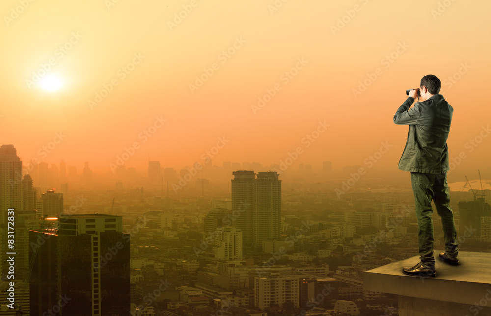 business man and binocular spying acting standing on top of offi business man and binocular spying acting standing on top of offi