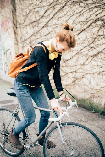 Smiling young woman riding bicycle on street
