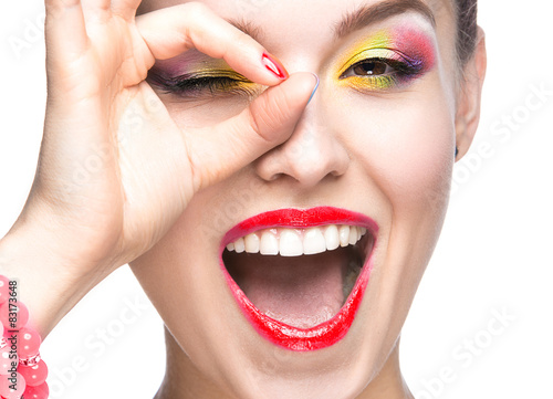 Beautiful girl with bright colored makeup and nail polish