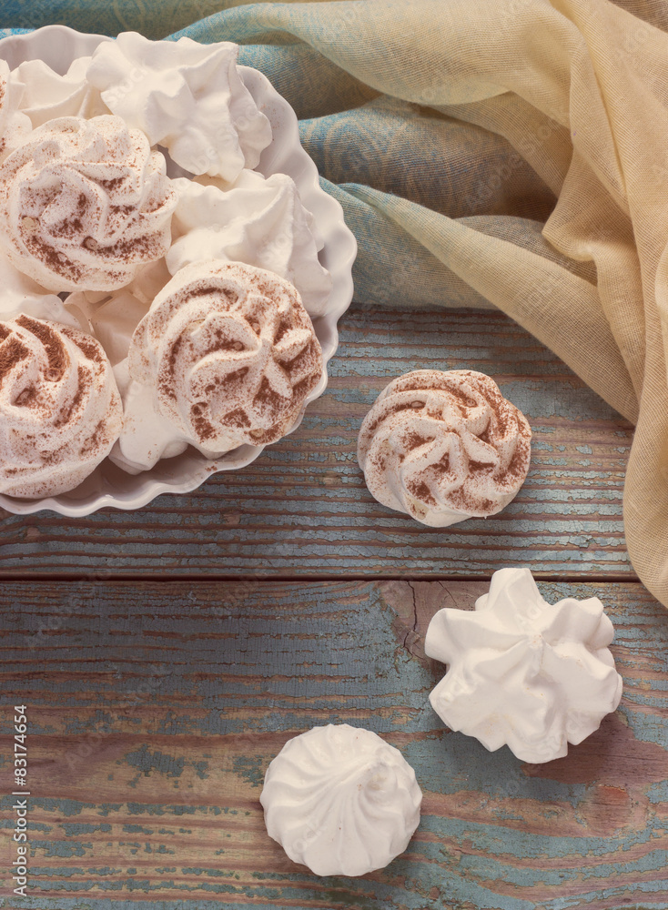 White meringue cookies on a wooden background 