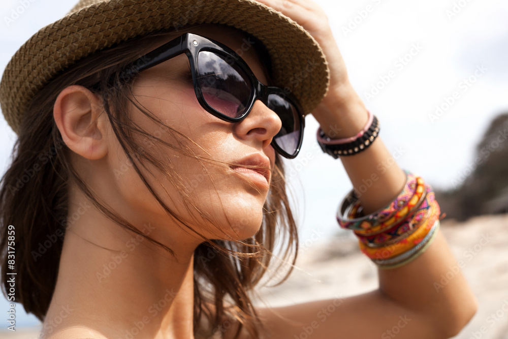 Naklejka premium young summer girl wearing a hat and sunglasses