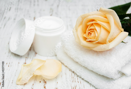 Rose with moisturiser cream and towels