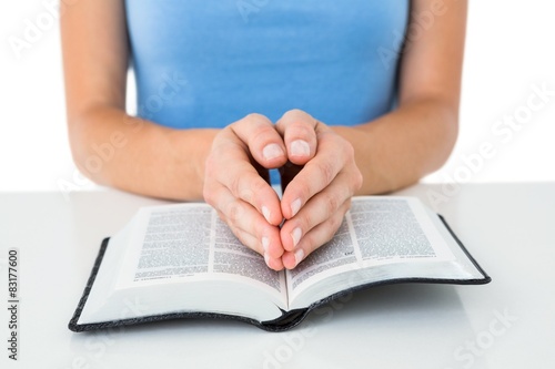 Woman praying while reading bible