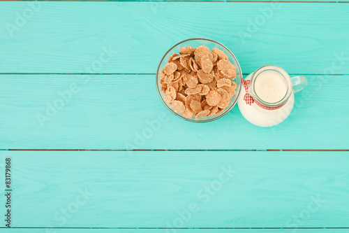 Jug of milk and muesli on blue wooden table. Top view