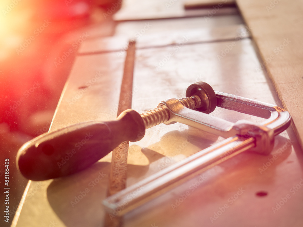 Real woodworking shop: clamps holding workpiece gluing, close-up Real woodworking shop: clamps holding workpiece gluing, close-up