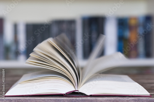 Aufgeschlagenes Buch vor Buecherregal