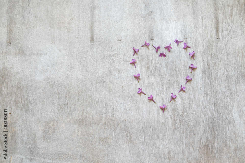 Flowers of lilac in the form heart on a wooden background