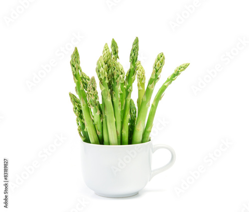 Asparagus arrange in a white cup on white background