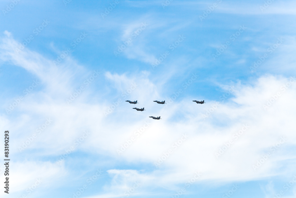 flight of military fighter planes in white clouds