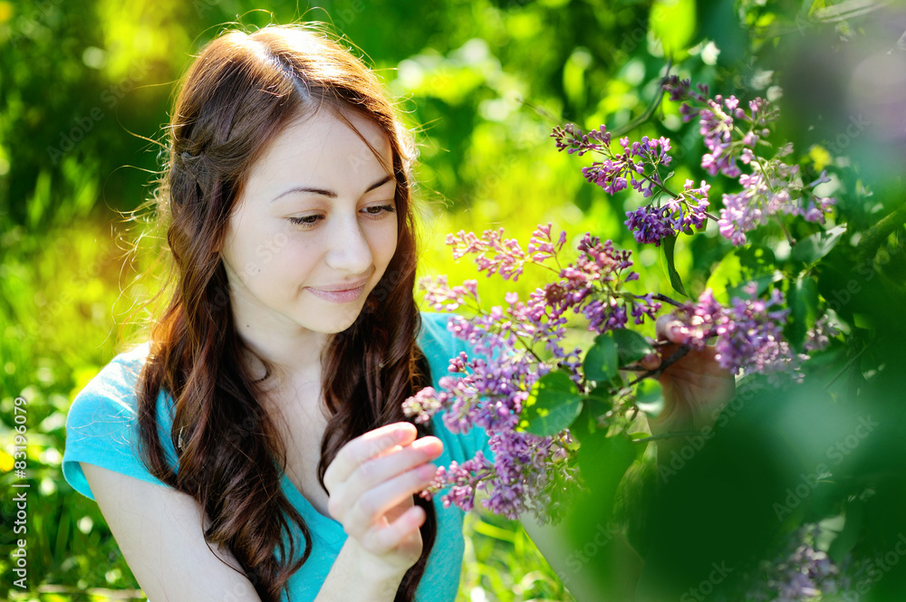 Beautiful woman walking among the trees of lilac in spring Beautiful woman walking among the trees of lilac in spring