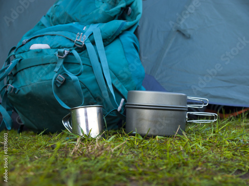Cookware for camping is on the grass on the background of a back