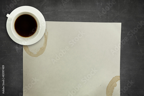 Black blackboard background with coffee cup and empty paper