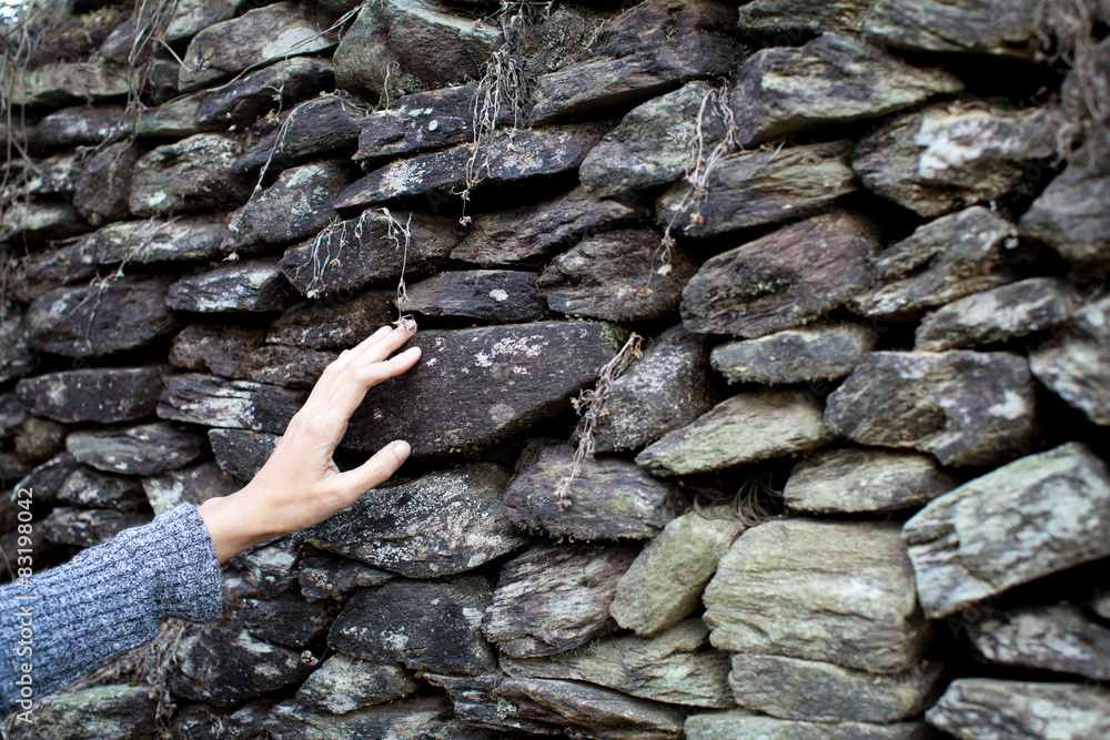 Touching the stone wall women hand