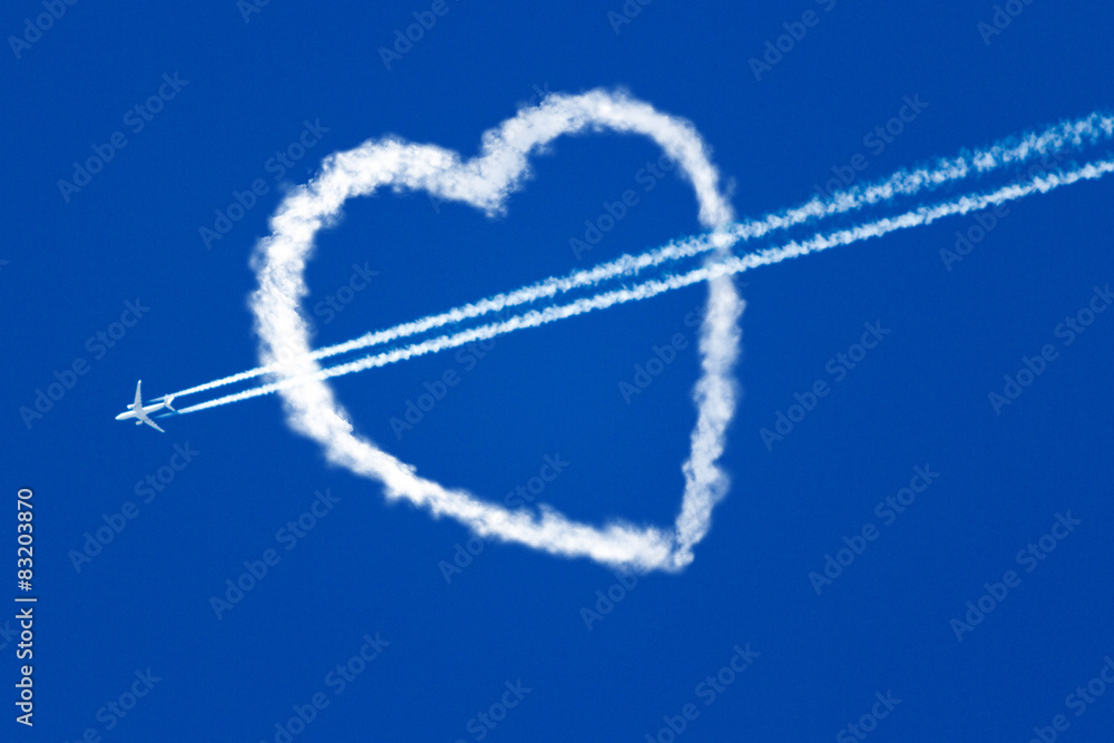 Fototapeta premium aircraft at the blue sky flying through the heart of the clouds