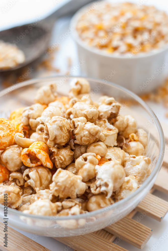 A bowl of popcorn on a wooden table, caramel popcorn A bowl of popcorn on a wooden table, caramel popcorn