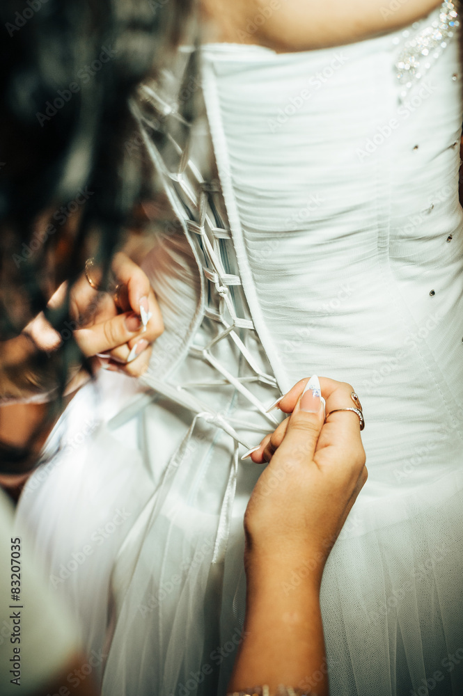 Fototapeta beautiful bride getting ready in white wedding dress with