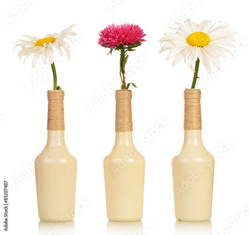Three flowers in vases