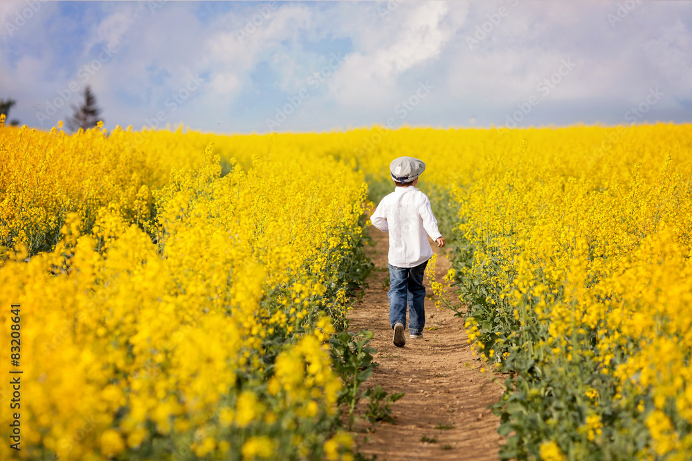 Adorable little boy, running in yellow oilseed rape field Adorable little boy, running in yellow oilseed rape field