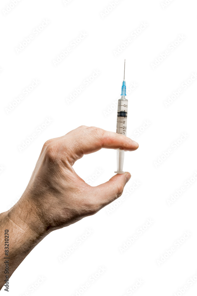 The hand holding the syringe with medication on a white backgrou The hand holding the syringe with medication on a white backgrou