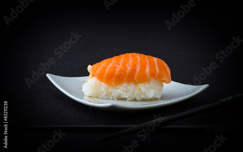 salmon nigiri sushi with chopstick on black