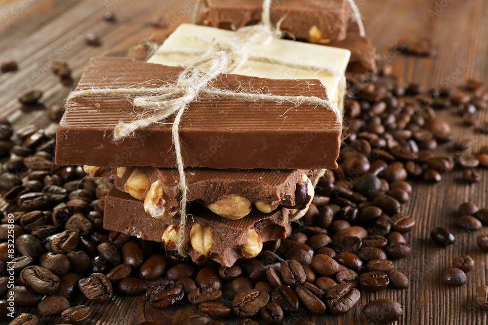 Stack of tied chocolate with coffee beans on wooden table, closeup Stack of tied chocolate with coffee beans on wooden table, closeup