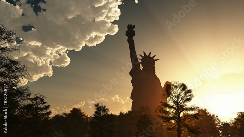 Statue of Liberty on the background of sunset and cloudy sky