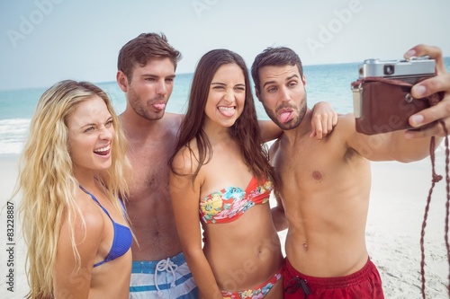 group of friends in swimsuits taking a selfie