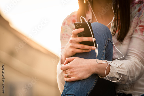 Woman looking to phone in street