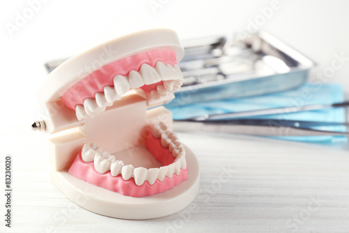 White teeth and dental instruments on table background