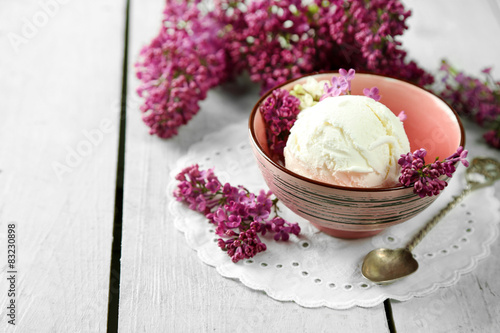 Beautiful composition with tasty ice cream and lilac flowers photo