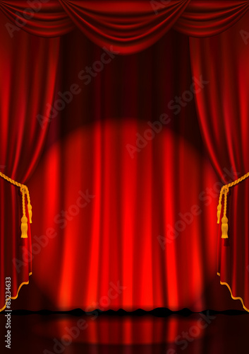 Theater stage with red curtains and spotlight.