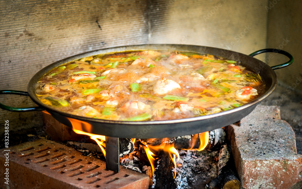 Cooking and making a traditional Spanish Paella over open fire w Cooking and making a traditional Spanish Paella over open fire w