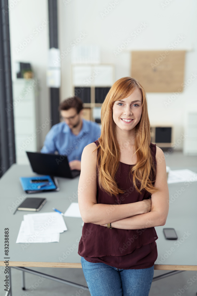 motivierte mitarbeiterin lehnt an ihrem schreibtisch im büro motivierte mitarbeiterin lehnt an ihrem schreibtisch im büro