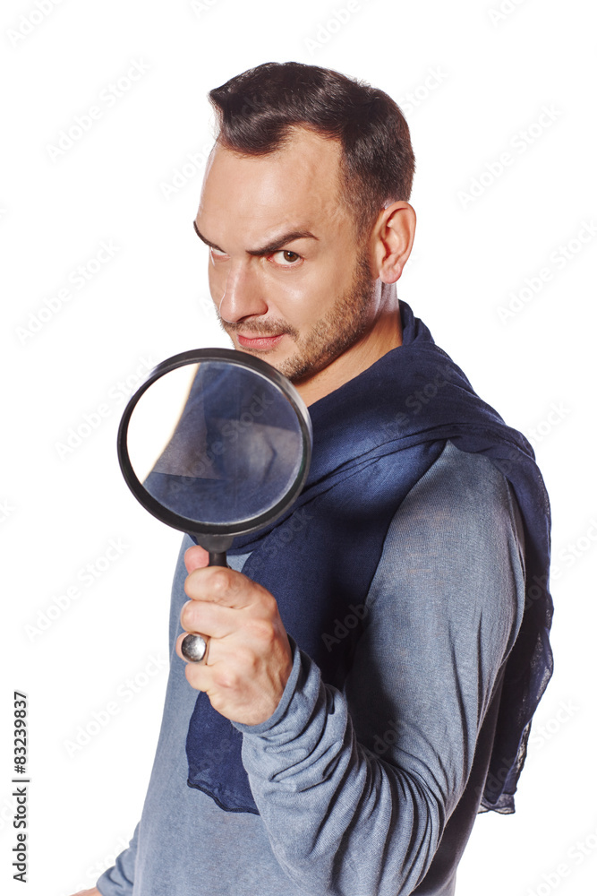 Serious man looking through magnifying glass Serious man looking through magnifying glass