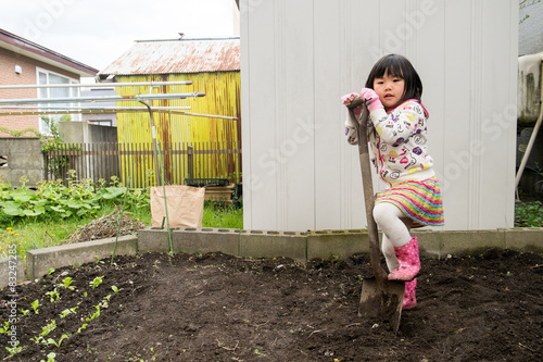 Bild auf Leinwand シャベルに足をかける子供