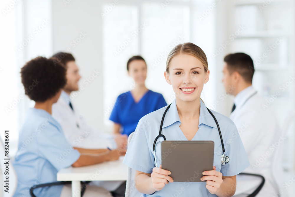 happy doctor with tablet pc over team at clinic happy doctor with tablet pc over team at clinic