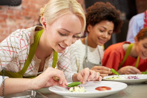 happy women cooking and decorating dishes