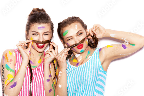 Two lovely painted girl friends having fun