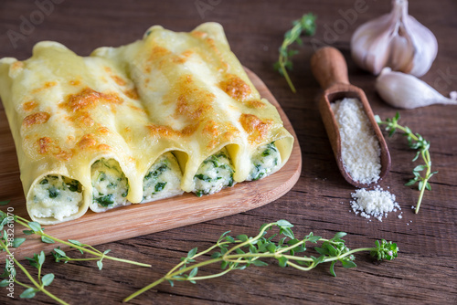 Cannelloni with ricotta and spinach on the wooden board photo