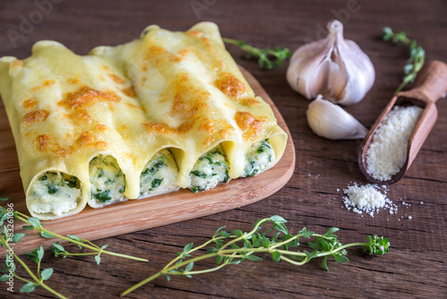 Cannelloni with ricotta and spinach on the wooden board photo