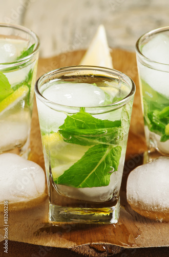 Glass of water with fresh lemon, ice and mint, selective focus