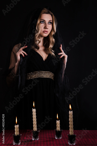 Young woman with candles in darkness