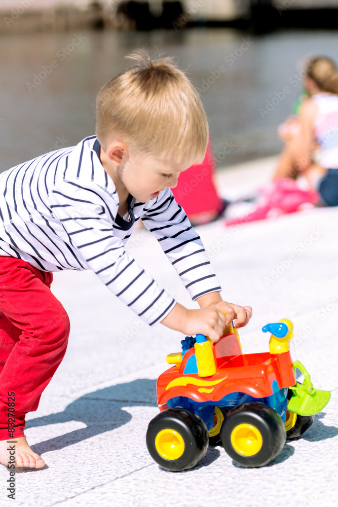 Little preschool boy playing with big toy car and having fun Little preschool boy playing with big toy car and having fun