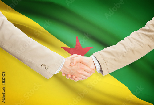 Businessmen handshake with flag on background - French Guiana photo