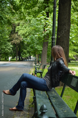 Samotna kobieta siedząca na ławce w parku