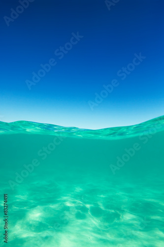 Clear waterline caribbean sea underwater and over with blue sky © ValentinValkov